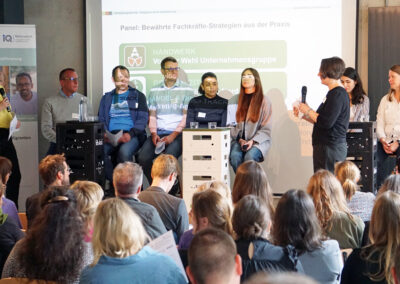 Mitarbeitende unterschiedlicher Firmen berichten auf der Bühne